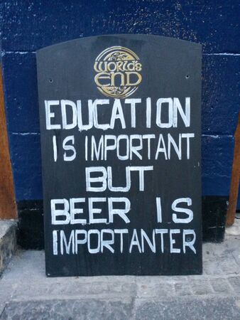 EDINBURGH, SCOTLAND, UK - CIRCA AUGUST 2015: Education is important but beer is importanter, funny pun wooden sign label before a pubのeditorial素材
