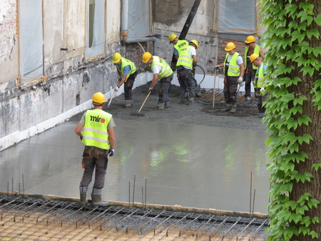CRACOW, POLAND - CIRCA MAY 2012: construction site workers laying crencrete floorのeditorial素材