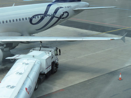 PRAGUE, CZECH REPUBLIC - CIRCA JULY 2016: Fuel tanker truck refilling an Air France Airbus A320-211 aircraft at the airportのeditorial素材