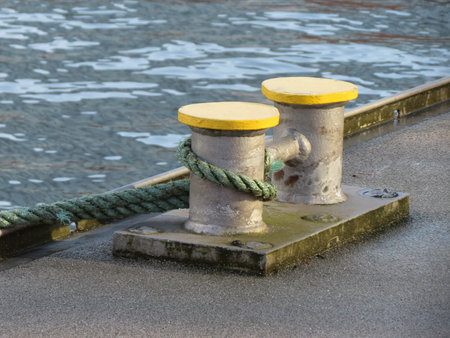 Double mooring bollard with a rope by a canal