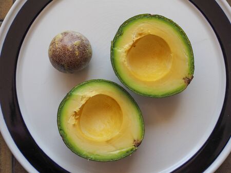 avocado cut in two parts in a dish with kernelの写真素材