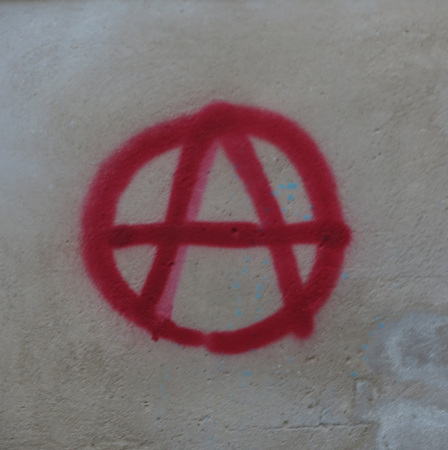 anarchy symbol painted in red paint on a wallの写真素材