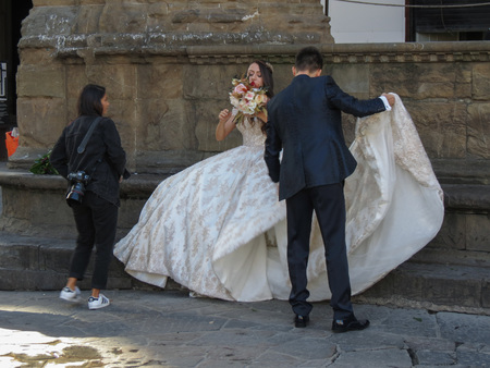 FLORENCE, ITALY - CIRCA OCTOBER 2018: bride in a wedding dress posing for pictures near Palazzo Vecchioのeditorial素材
