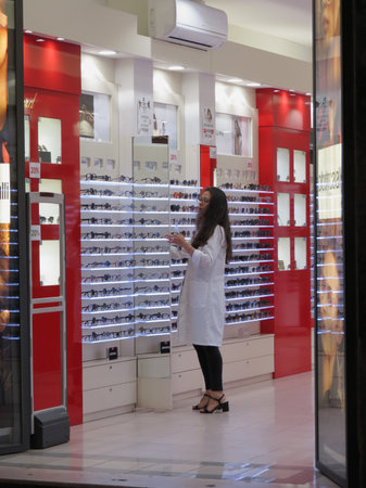 FLORENCE, ITALY - CIRCA OCTOBER 2018: shop assistant wearing a white lab coat ina lenses and glasses...