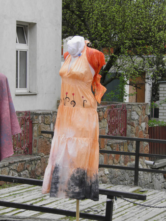 KARLSTEJN, CZECH REPUBLIC - CIRCA APRIL 2011 - woman mannequin with orange dress in a street marketのeditorial素材