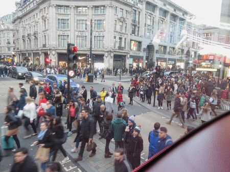 LONDON, UK - CIRCA NOVEMBER 2019: a crowd of people crossing Oxford Circus, at the corner between Regent Street and Oxford Streetのeditorial素材