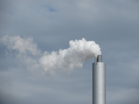 Air pollution by smoke coming out of factory chimney