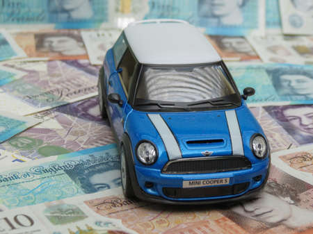 LONDON, UK - CIRCA MAY 2020: light blue Mini car miniature replica over GBP notesのeditorial素材