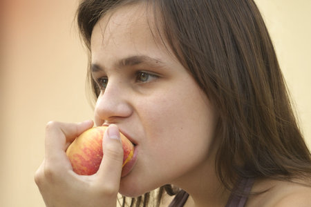 girl eating big peachの写真素材