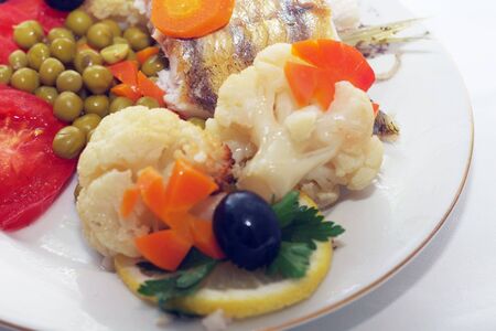 baked fish with mixed greens garnishの写真素材
