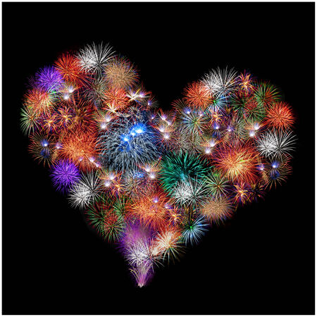 a group of exploding fireworks shaped like a heart in the night sky の写真素材