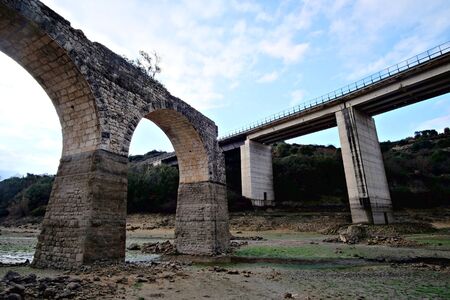 old ruined bridge and modern overpassの写真素材