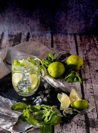 Mojito cocktail with lime and mint in a glass glass on a gray stone base.の写真素材