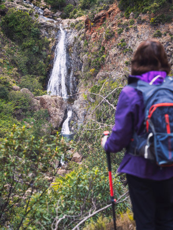 Woman in the middle of nature enjoying the view of a waterfall in the middle of Mediterranean...