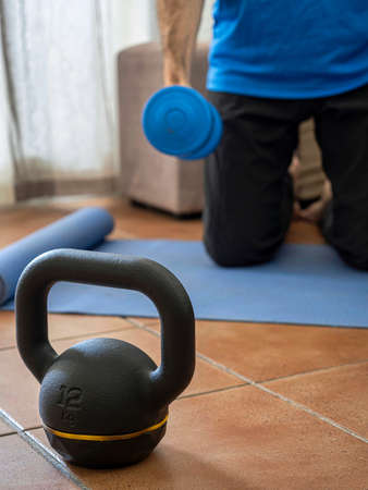 Fitness concept. Dumbbell on the floor. Man starting strength training. Motivation to perform. Determination, challenge. Copyspace.の写真素材