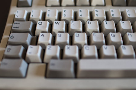 QWERTY Button on old keyboard with mechanical buttons of ivory and gray color. Computer from 90s