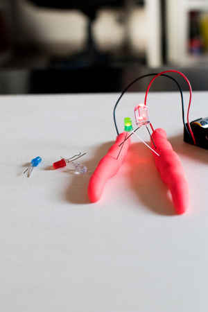 Electronic soft circuits with LEDs, batteries and modeling clay. Set for electronic education for children. Stem activity with green leds lights onの写真素材