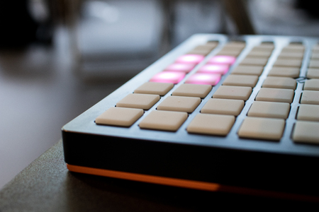 musical instrument for electronic music with a matrix of 64 keys in 8 x 8 files.
Pad for music with buttons on top illuminated by purpleの写真素材