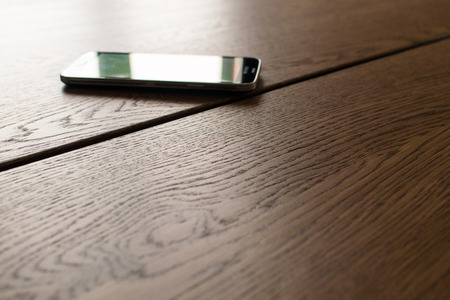 wooden meeting table with blurred smartphone in the background. Business activity in the morningの写真素材