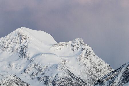 Mountain silhouette profile in arctic landscape with snow and ice. Snowy mountain on a blue sky and clouds, profile of a mountain with snow and ice. Winter landscapeの写真素材