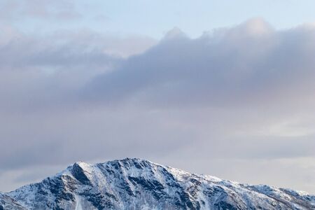 Mountain silhouette profile in arctic landscape with snow and ice. Snowy mountain on a blue sky and clouds, profile of a mountain with snow and ice. Winter landscapeの写真素材