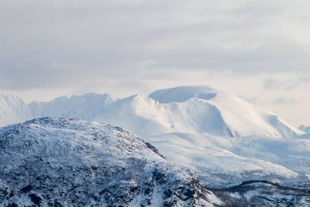 Mountain silhouette profile in arctic landscape with snow and ice. Snowy mountain on a blue sky and clouds, profile of a mountain with snow and ice. Winter landscapeの写真素材