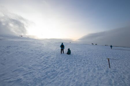 Polar landscape with snow and wind in the mountains. Hiking and snow hiking in the mountains with footprints on the ice and snow. Adventure and excursions in the cold in winterの写真素材