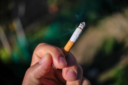 Human hand hold cigarette while smoking,no smoke concept,people health careの写真素材