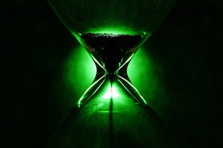 Crystal Hourglass on green background, inspirational time pass concept close upの写真素材