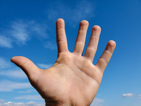 Human hand over clear blue sky background,man power concepts, freedom