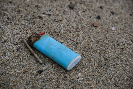 Salt Corroded Plastic lighter trash on sandy sea ecosystem,microplastics sea coast pollution