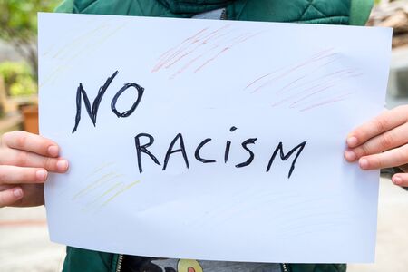 Child boy hold a paint draw for support no racism protest in usa,no racism,educationの写真素材