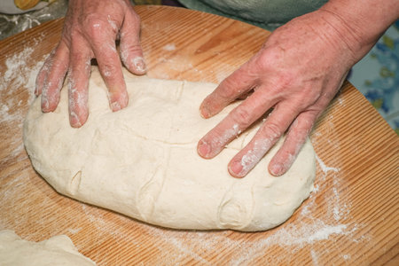 Grandmother kneading dough to prepare homemade bread and pastries at home,kitchen lifestyle