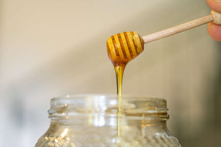 Raw tasty Honey on a wooden dipper closed up,Breakfast healthy ingredientsの写真素材