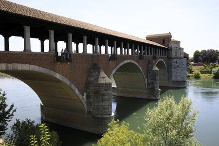 Pavia (PV), Italy - June 09, 2018: The Ponte Coperto (covered bridge), also known as the Ponte Vecchio (old bridge), a brick and stone arch bridge over the Ticino River in Pavia, Lombardy, Italyのeditorial素材