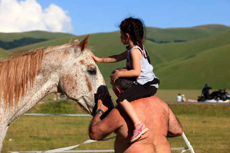 Norcia (PG), Italy - May 25, 2015: A child caressing a horse in the country near Castelluccio di Norcia, Highland of Castelluccio di Norcia, Norcia, Umbria, Italy, Europeのeditorial素材