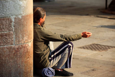 Ferrara (FE), Italy - June 10, 2017: A man begs for money on a central street in Ferrara, Emilia Romagna, Italyのeditorial素材