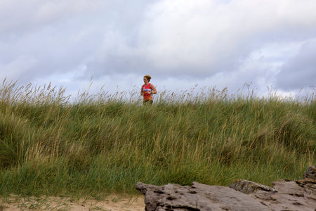 Dornoch (Scotland), UK - August 03, 2018: A woman running at Dornoch Beach, Dornoch, Scotland, Highlands, United Kingdomのeditorial素材