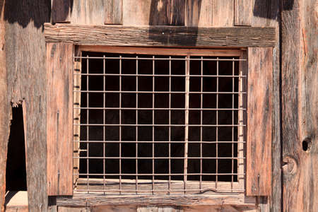 Calico, California / USA - August 23, 2015: An old window with a grate in Calico Ghost Town, Calico, California, USAのeditorial素材