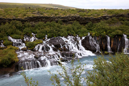 Hraunfossar / Iceland - August 15, 2017: Hraunfossar waterfalls formed by rivulets streaming out of the Hallmundarhraun lava field formed by the eruption of a volcano lying under the glacier Langjokul., Iceland, Europeのeditorial素材