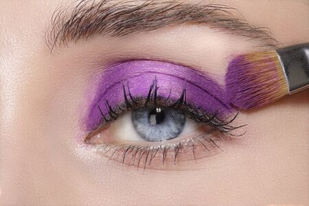Close up on eyes , making colorful eyeshadows and eyeliner tutorialの写真素材