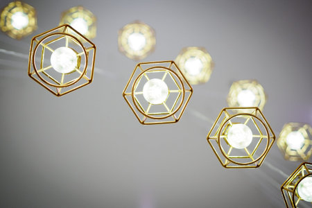 Gold colored wire frame hanging lamps. Bottom view. Landscape format.