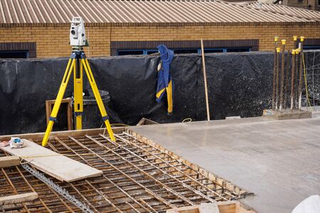 A theodolite on use on a partially cast concrete slab in a construction site. Landscape format.の写真素材