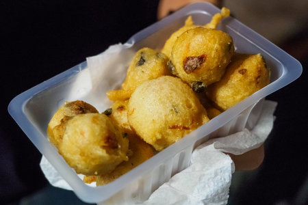 Traditional pittule (or pettule), fried sourdough balls flavored with peppers and capers. Landscape...