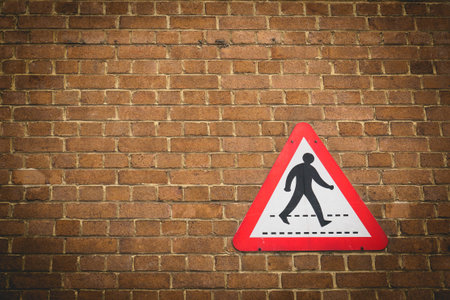 Vintage pedestrian crossing sign on a brick wall background. Landscape format.