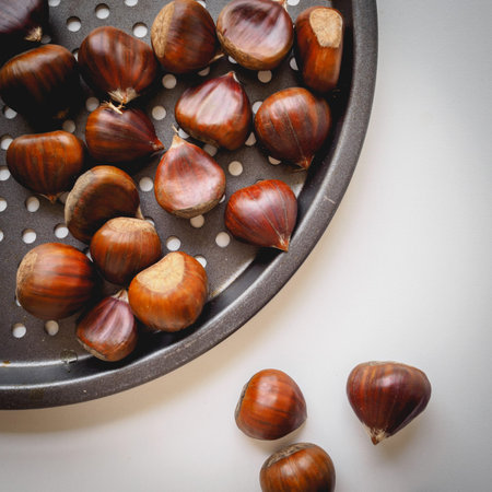 Top view of chestnuts in a pan on a white background. Square format.の写真素材