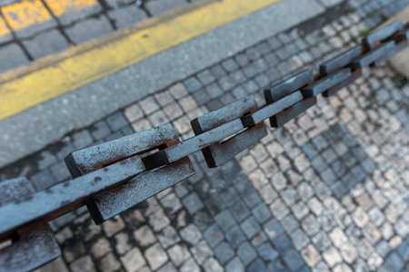 Steel rusty chain on the street on a pedestrian zone.