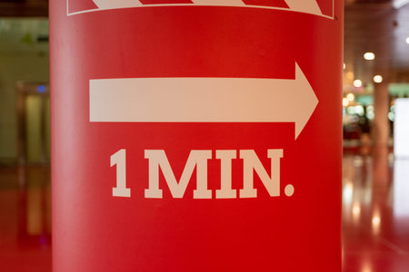 White emergency exit arrow on red background.