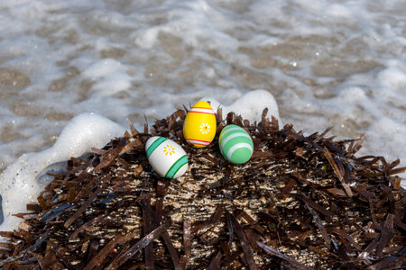 Colorful Easter eggs on the beach in sunny day. Easter concept.の写真素材