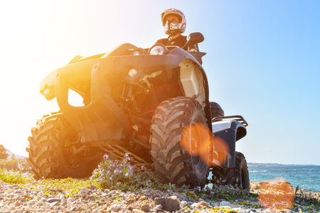 A man is driving ATV on off-road. Sunny.の写真素材